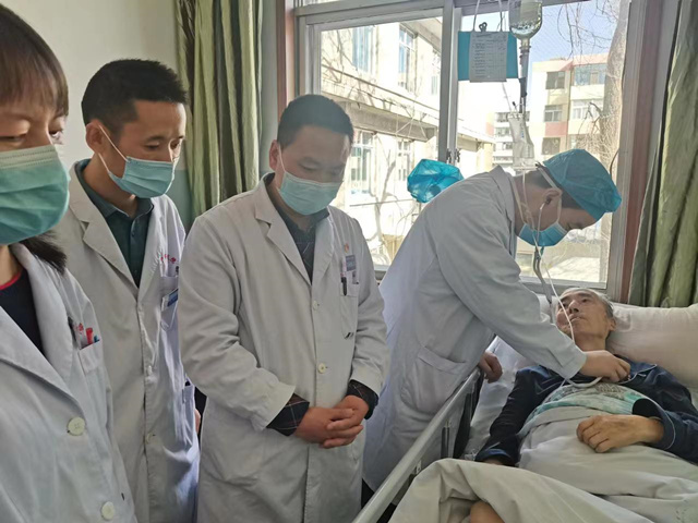 医生对病人进行复查。西宁市第二人民医院供图