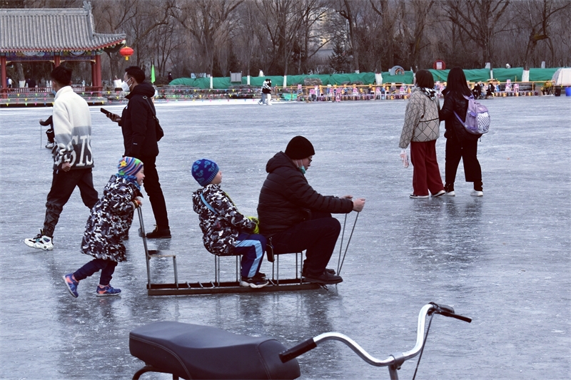 市民在人民公园人工湖冰雪场上嬉戏。小澍摄