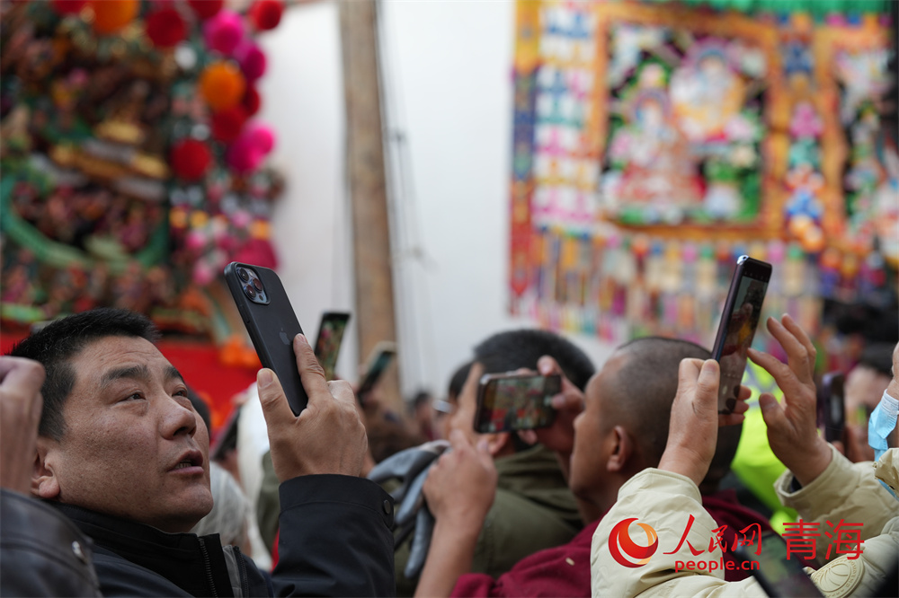 2月24日，青海湟中塔尔寺酥油花灯节游客游客在酥油花架前拍照。人民网记者 甘海琼摄 