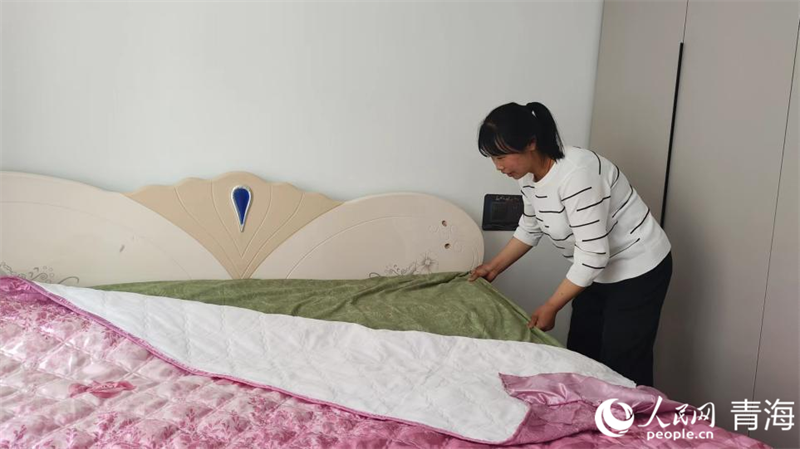 黄桂英正在整理新家的床铺。人民网记者 张莉萍摄