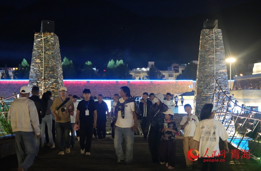 游客在玉樹巴塘河畔步行街。人民網記者 甘海瓊攝