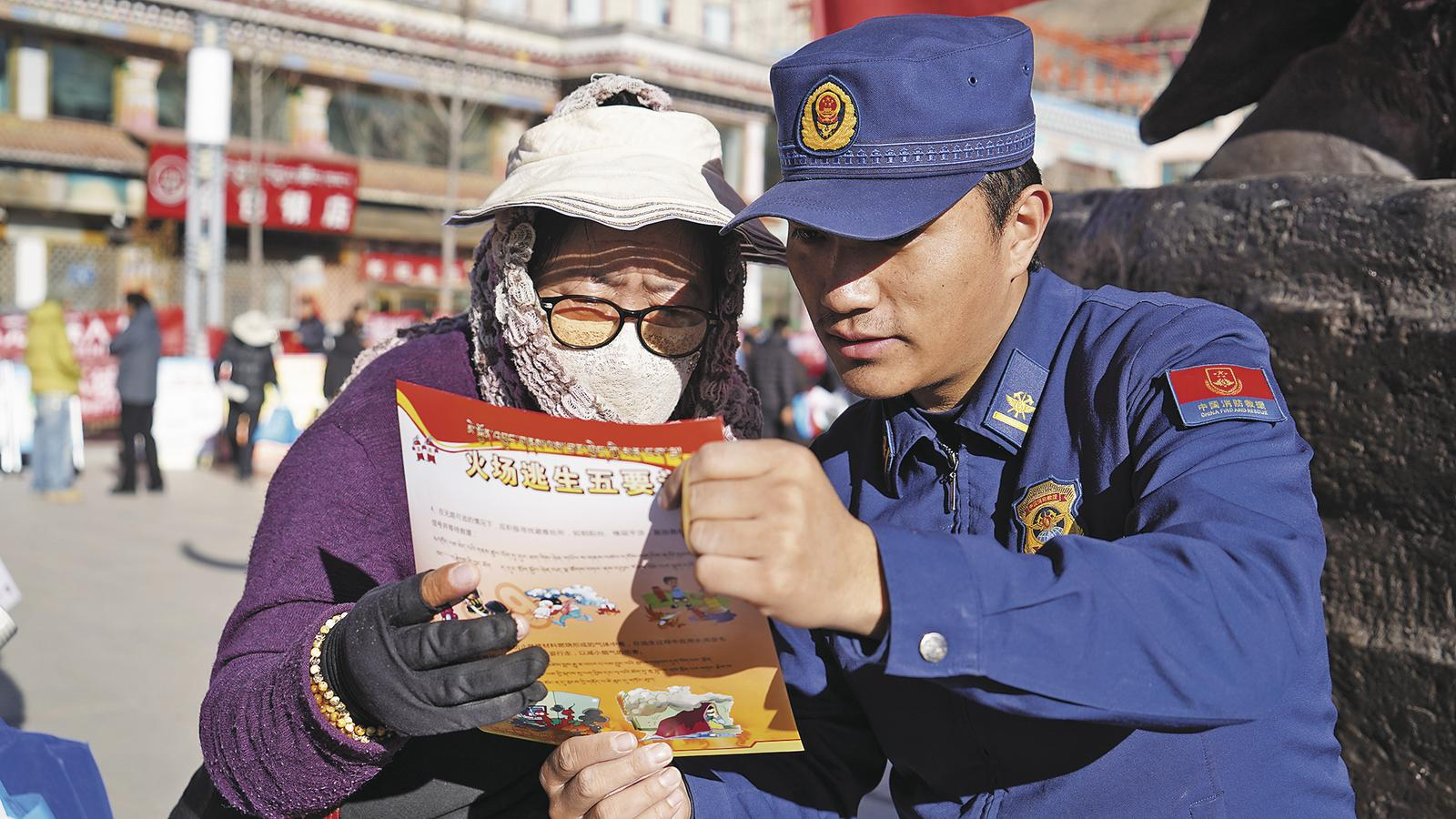 玉树藏族自治州消防救援支队宣传员为群众讲解消防安全知识。青海省消防救援总队供图