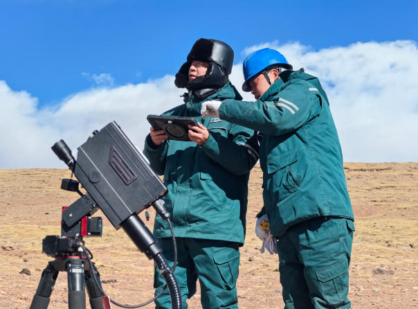 春节前,“唐古拉之鹰”电力天路运维班安全员应洪和同事使用激光炮消除“电力天路”导线上的异物。谢莉蓉摄