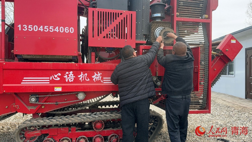 和農戶一起檢修農機。人民網記者 況玉攝