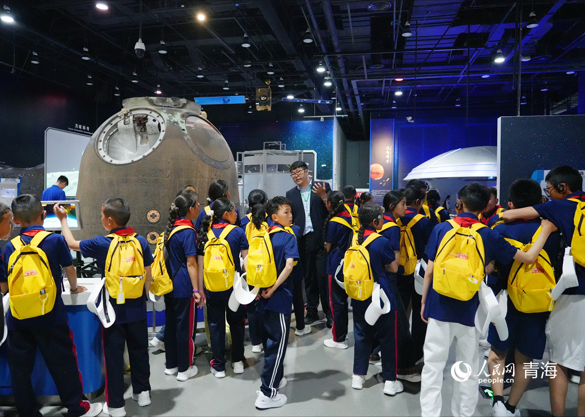 玉樹少年聽講解員講解航空航天知識。人民網記者 楊啟紅攝