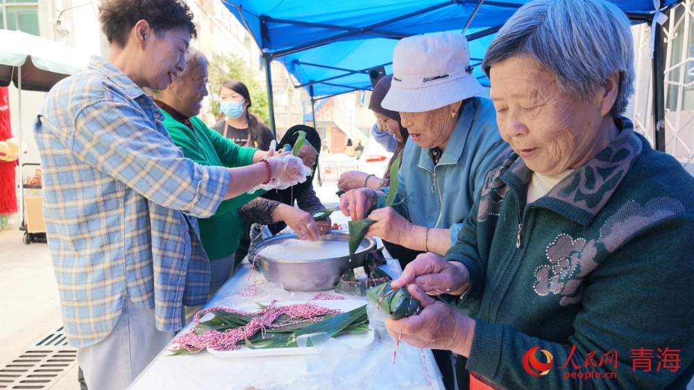 市民其乐融融包粽子。人民网记者 况玉摄