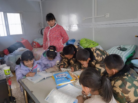 12月25日，在青海省海东市民和县喇家村集中安置点，学生们正准备上课。人民网 白波摄