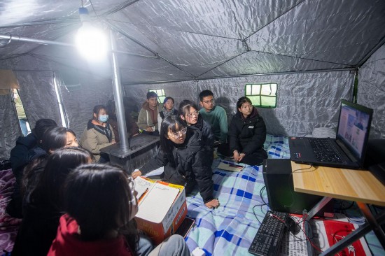 12月22日，在甘肃省临夏州积石山县大河家镇大河村集中安置点，部分高中学生在帐篷中听课。人民网记者 翁奇羽摄